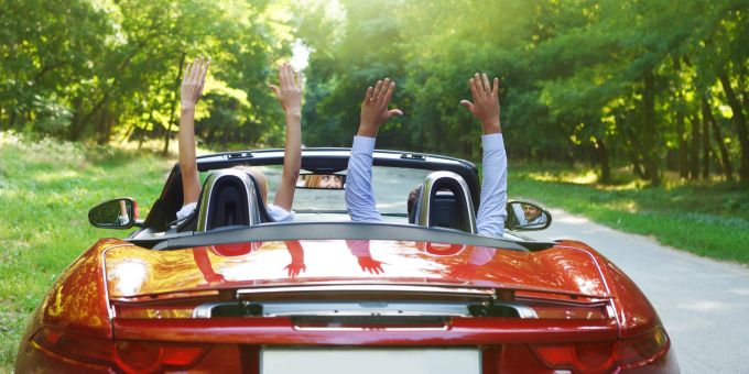 Bei einem Road Trip kann man mit ein paar Tipps viel Geld beim Benzin sparen. Cabriolet, Paar, Freude, Jubel, Roadtrip