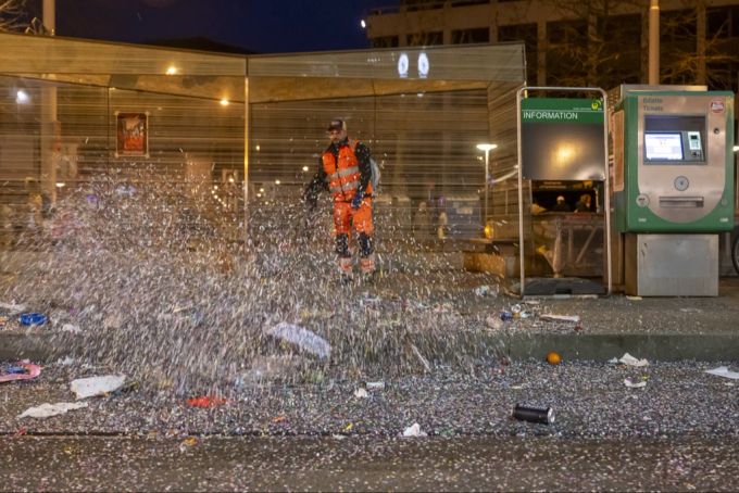 Eine Tramhaltestelle wird von der Stadtreinigung von Räppli und anderem Abfall befreit. basler fasnacht
