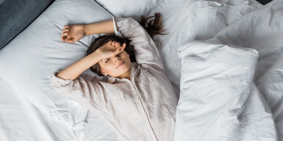 Frau schläft im Bett.