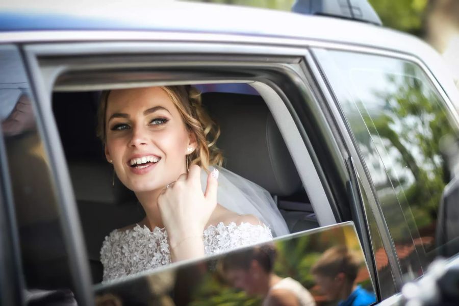 Braut sitzt im Auto.