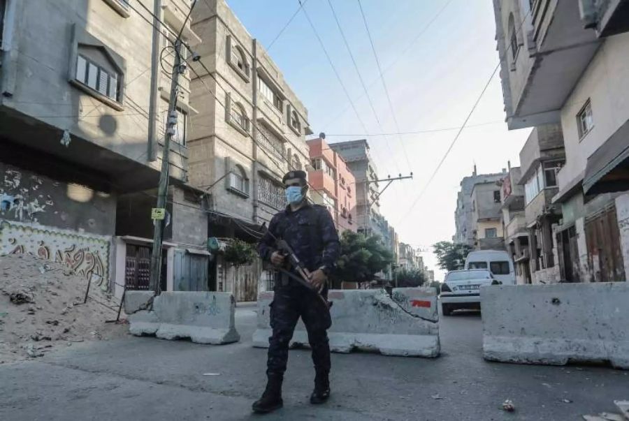 Ein Hamas-Polizist bewacht eine Betonbarriere an einer Strasse.