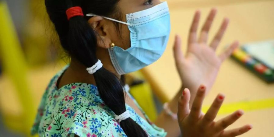 Gehört mittlerweile in den Klassenzimmer dazu: Die siebenjährige Bushra trägt eine Maske. Foto: Andreas Arnold/dpa