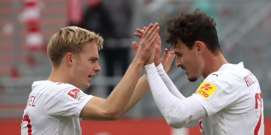 Kiels Janni Serra (r) und Finn Porath jubeln. Nach dem Sieg gegen Heidenheim steht Holstein Kiel vorerst auf Platz eins. Foto: Daniel Karmann/dpa
