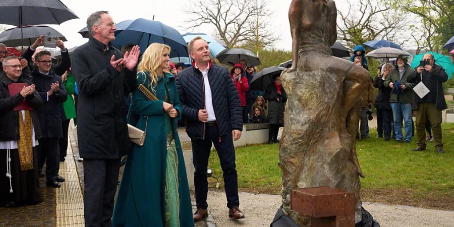 Michael Ebling (SPD, l), rheinland-pfälzischer Innenminister, Loreley Katharina Blanckart und Verbandsbürgermeister Mike Weiland enthüllen die neu gestaltete Loreley-Statue auf dem Loreley-Plateau hoch über dem Rhein. Foto: Thomas Frey/dpa