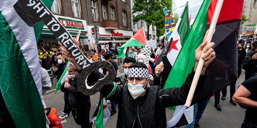 Teilnehmer einer Palästinenser-Demonstration laufen durch Neukölln.