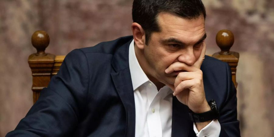 Alexis Tsipras hält seine Hand vors Gesicht.