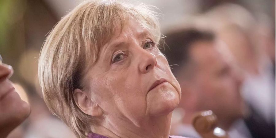 Bundeskanzlerin Angela Merkel sitzt bei den Feierlichkeiten zum Tag der Deutschen Einheit in einem Gottesdienstes.