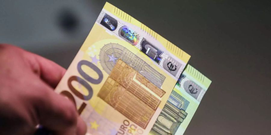 Ein Mann hält zwei 200-Euro-Scheine in der Hand.