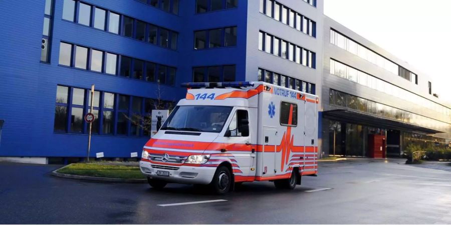 Eine Ambulanz verlässt ein Wohngebäude. (Symbolbild)