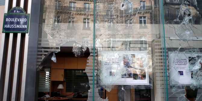 Blick auf die eingeschlagenen Fenster einer Bank.