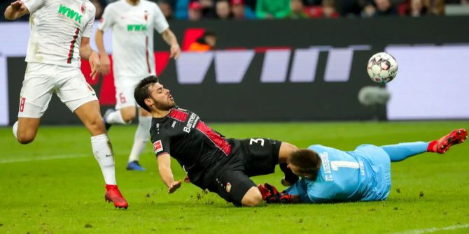 Kevin Volland (L) prallt mit FC Augsburgs Andreas Luthe (R) zusammen.