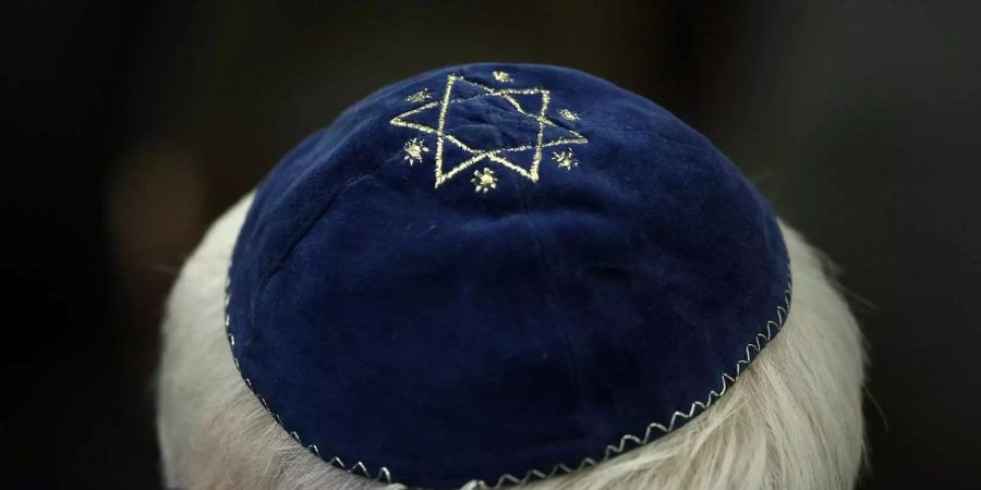 Ein Mann trägt in der Synagoge in Mainz eine Kippa mit einem aufgenähten Stern.