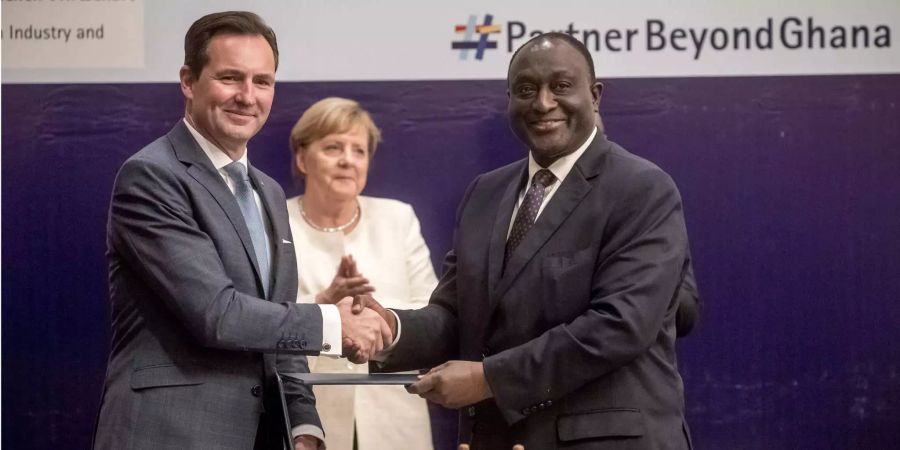 Thomas Schäfer, Leiter des Südafrika-Geschäfts von Volkswagen, überreicht Alan John Kwadwo Kyerematen, Handelsminister von Ghana, die unterschriebene Verständigungserklärung zu geplanten Investitionen. Bundeskanzlerin Angela Merkel ist im Rahmen eines Wirtschaftsdialogs vor Ort.