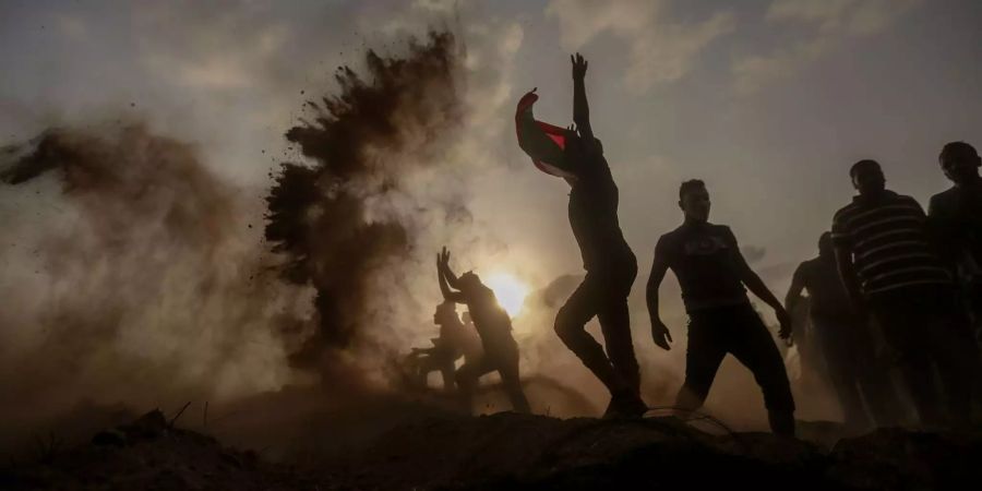 Palästinensische Demonstranten werfen Sand in die Luft bei Zusammenstössen mit israelischen Sicherheitskräften entlang der Grenze Schutz.