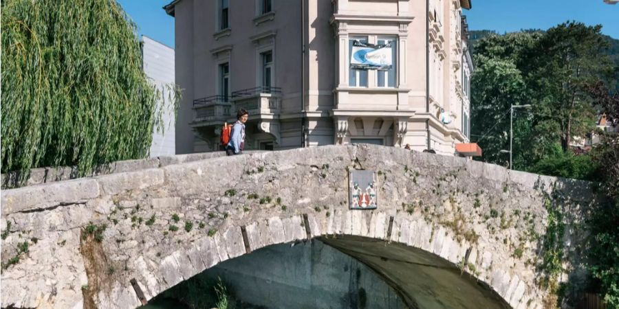 Eine Frau überschreitet die Pont de la Maltiere in Delemont JU.