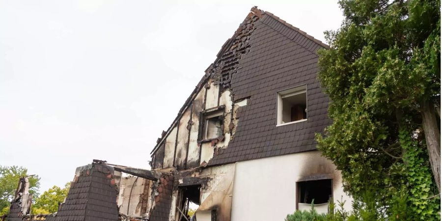 Die Fassade eines Hauses ist nach einem Brand teilweise zerstört.