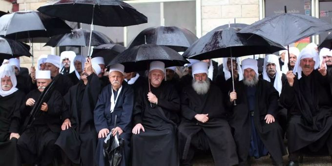 Mehrere Dutzend Druzen wurden in Syrien von dem IS verschleppt. Jetzt sind sie wieder frei. Ein Gruppe von Drusen sitzen in einem Dorf nahe der syrisch-israelischen Grenze bei der Golanhöhe im Regen.