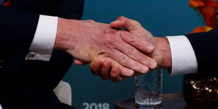 Donald Trump (l), Präsident der USA, und Emmanuel Macron, Präsident von Frankreich, geben sich während des G7 Gipfels bei einem bilateralem Treffen die Hand.