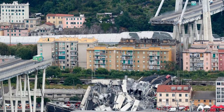 Ein Lastwagen (l) steht auf der Autobahnbrücke Ponte Morandi kurz vor der Stelle, an der die Brücke eingestürzt ist