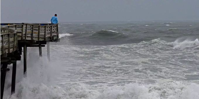 Ein Mann betrachtet die schwere Brandung am Pier, während sich Hurrikan «Florence» trotz verminderter Windstärke mit grosser Zerstörungskraft der Südostküste der USA nähert. Ein Mann betrachtet die schwere Brandung am Pier, während sich Hurrikan «Florence» trotz verminderter Windstärke mit grosser Zerstörungskraft der Südostküste der USA nähert.