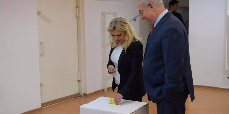 Benjamin Netanjahu, Premierminister von Israel, steht neben seiner Frau Sara Netanjahu während sie ihren Stimmzettel in die Wahlurne in einem Wahllokal steckt.