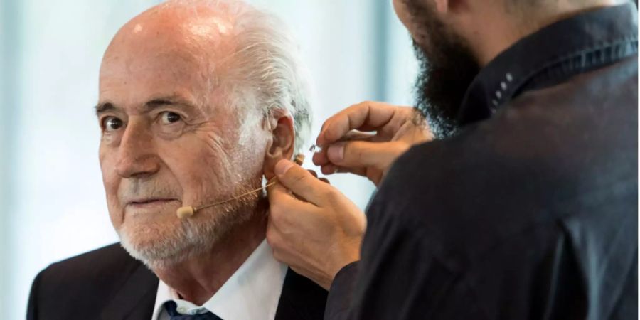 Der ehemalige Fifa-Präsident Sepp Blatter lässt sich ein Mikrofon anbringen.