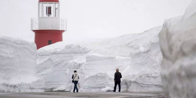 Fussgänger laufen entlang der Strasse des Oberalppasses und überqueren den am Freitag 27. April 2018 geöffneten und noch mit hohen Schneewänden bedeckten Oberalppass zwischen Andermatt und Sedrun. Fussgänger laufen entlang der Strasse des Oberalppasses.