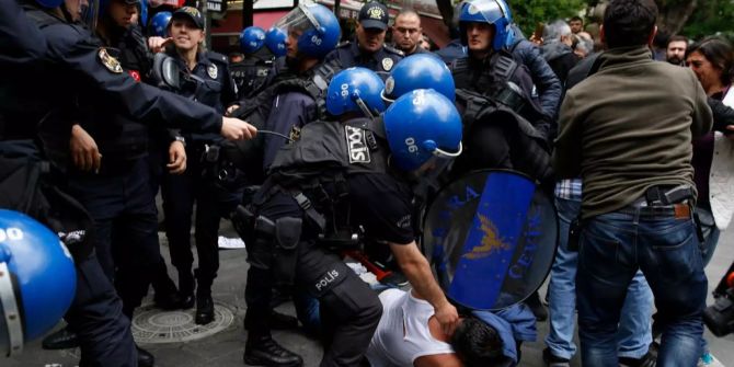 Türkische Polizisten halten einen Demonstranten auf dem Boden fest.