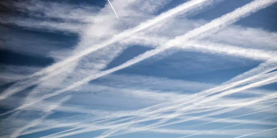 Flugzeuge haben zahlreiche Kondensstreifen am blauen Himmel gezogen.