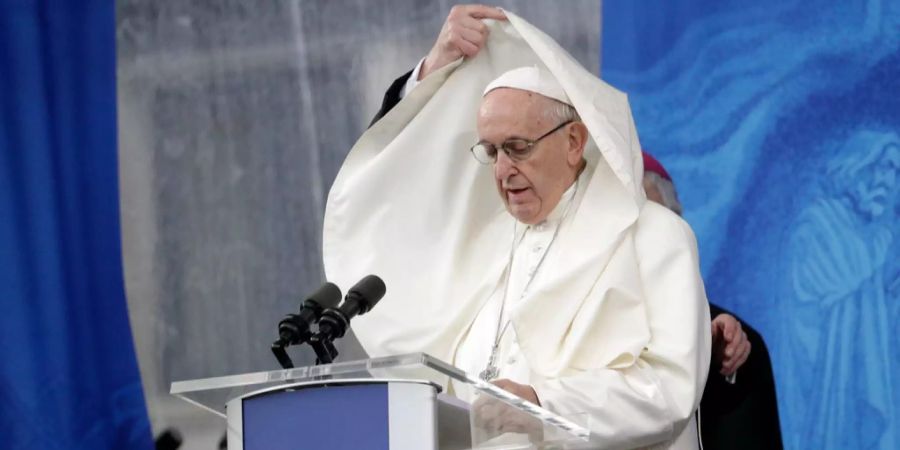 Ein Assistent des Papstes richtet seine Kleidung.
