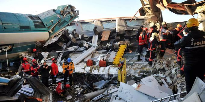 Rettungsdienstmitarbeiter stehen inmitten der Trümmer eines entgleisten Zuges. Rettungsdienstmitarbeiter stehen inmitten der Trümmer eines entgleisten Zuges.