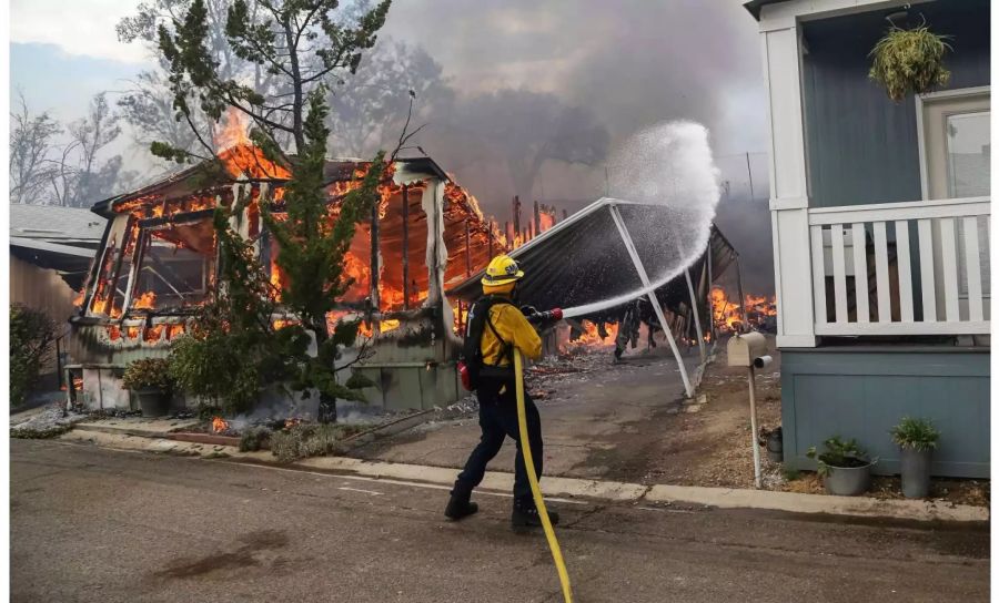 Ein Feuerwehrmann kämpft in Alpine gegen die Flammen.