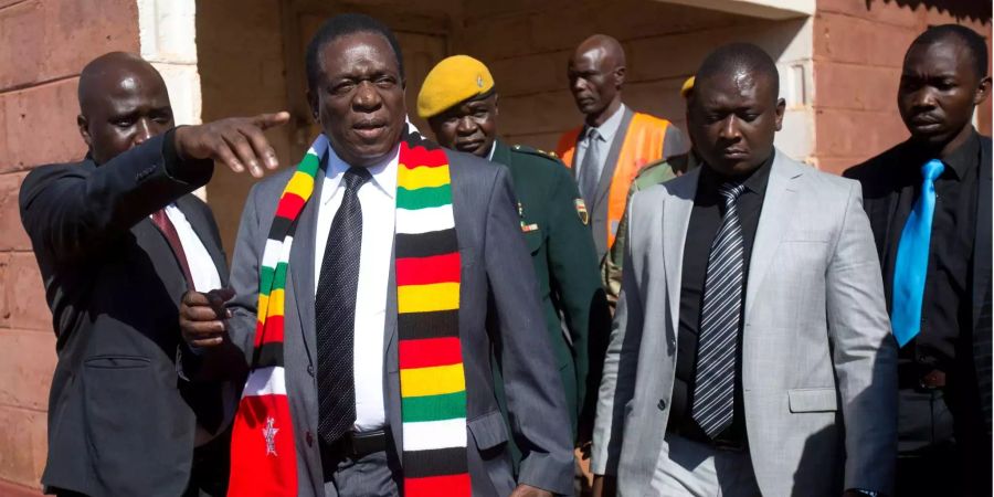 Emmerson Mnangagwa (2.v.l), Präsident von Simbabwe, verlässt ein Wahllokal, nachdem er seine Stimme abgegeben hat. Rund acht Monate nach dem Militärputsch in Simbabwe wird in dem Land ein neuer Präsident gewählt.