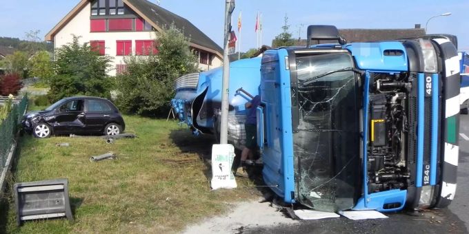 Der Lastwagen liegt nach dem Unfall auf der Seite liegend am Boden. Der Lastwagen liegt nach dem Unfall auf der Seite liegend am Boden.