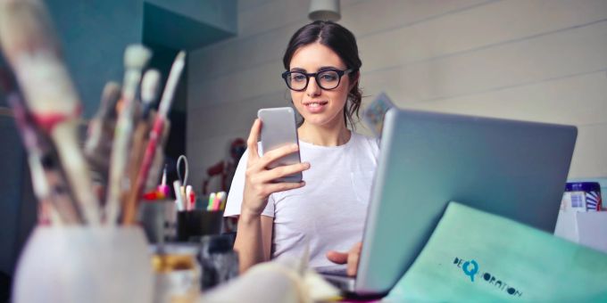 Online-Tools wie Doodle helfen beim Planen gemeinsamer Termine. Frau an Handy