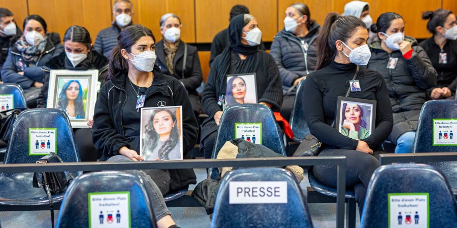 Angehörige der Getöteten sitzen mit Porträtfotos der Frau beim Prozessauftakt in einem Saal vom Landgericht Hildesheim. Auch am zweiten Verhandlungstag wurden viele Bilder mitgebracht.