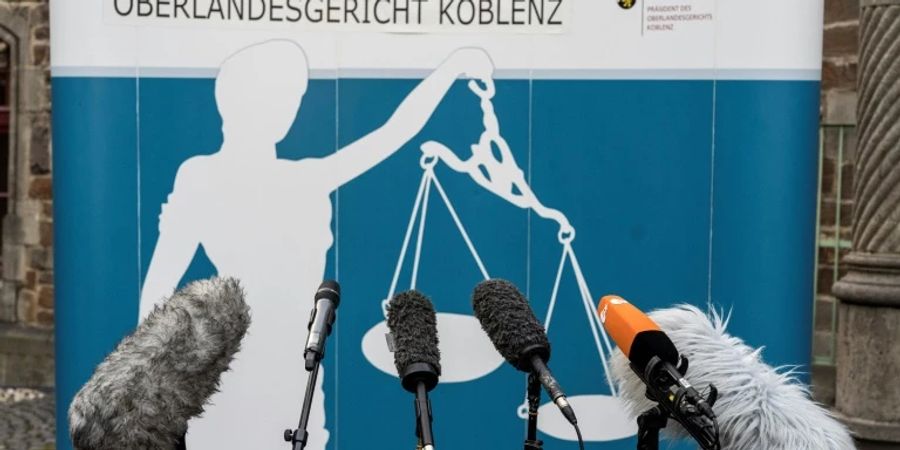 Mikrofone vor einem Banner am Oberlandesgericht Koblenz