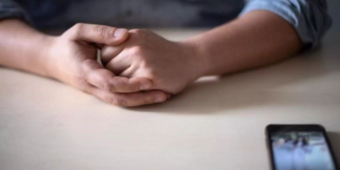 Ein Smartphone liegt vor einem Mann auf dem Tisch. Soziale Medien haben auch eine dunkle Seite. Besonders Kinder und Jugendliche machen immer wieder negative Erfahrungen. Sexuelle Belästigung Smartphone