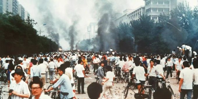 Rauchsäulen, Verwüstung und ratlose Menschen am 4. Juni 1989 auf der Changan Avenue in Peking. Foto: Kyodo News tian?anmen-massaker