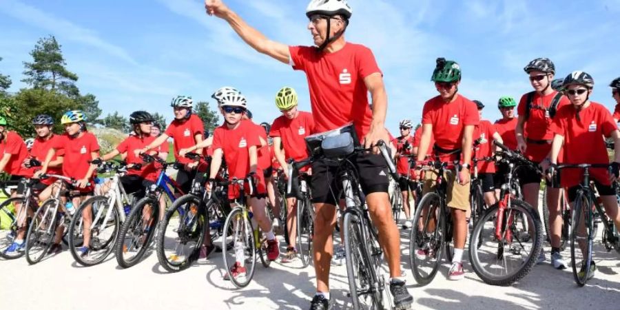 Der ehemalige Radrennfahrer Ortwin Czarnowski (M) startet auf dem Gelände der Bundesgartenschau 30 Jahre nach dem Mauerfall eine über 700 Kilometer lange Schüler-Fahrradtour mit dem Titel «Rollendes Klassenzimmer» von Heilbronn nach Berlin. Foto: Bernd Weissbrod