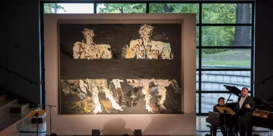 Der Opernsänger Matthias Goerne singt vor dem Gemälde «Immer noch unterwegs» von Georg Baselitz aus dem Jahr 2014. Foto: Jens-Ulrich Koch
