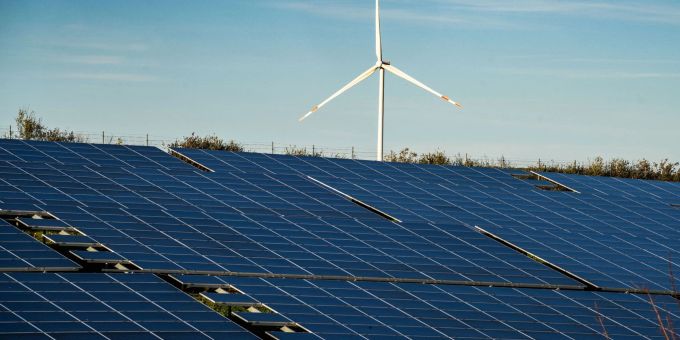 Ein Windrad steht auf einem Hügel einer grossflächigen Solaranlage. Ein Windrad steht auf einem Hügel einer grossflächigen Solaranlage.