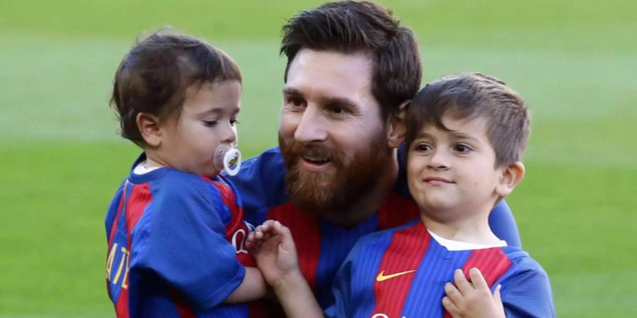 Der zweijährige Mateo (l.), Vater Messi (M.) und der fünfjährige Thiago (r.). umarmen sich nach einem Spiel des FC Barcelona.