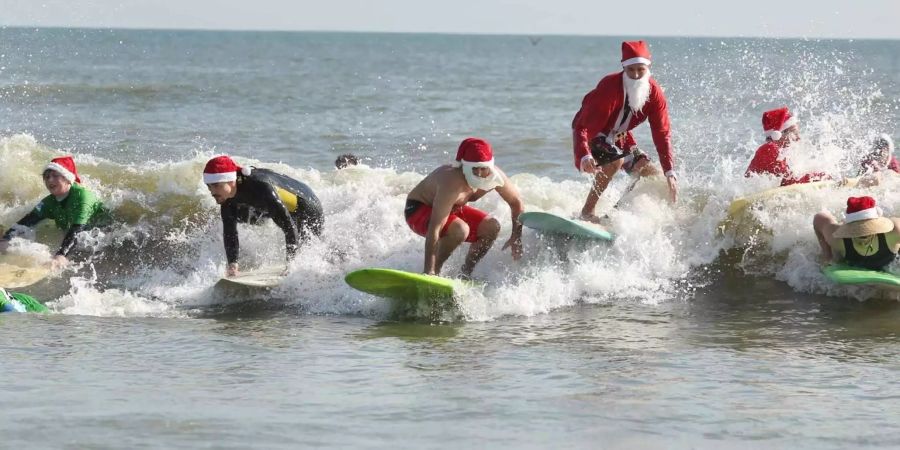 In Florida nahmen Surfer in unterschiedlichen Weihnachtsmannkostümen am diesjährigen «Surfing Santa» teil.