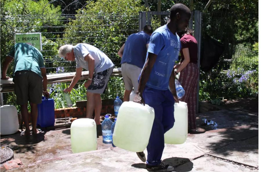 Bürger füllen Wasserkanister an einer natürlichen Quelle in Kapstadts Vorort Newlands auf.