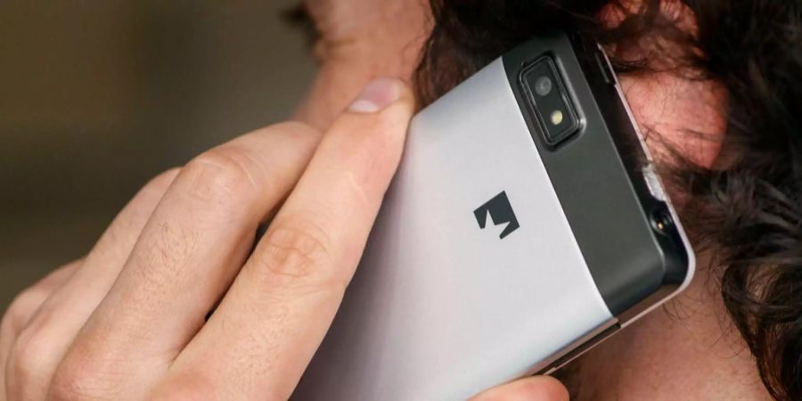 Ein Mann telefoniert mit einem Fairphone, einem Mobiltelefon produziert unter fairen Arbeitsbedingungen.