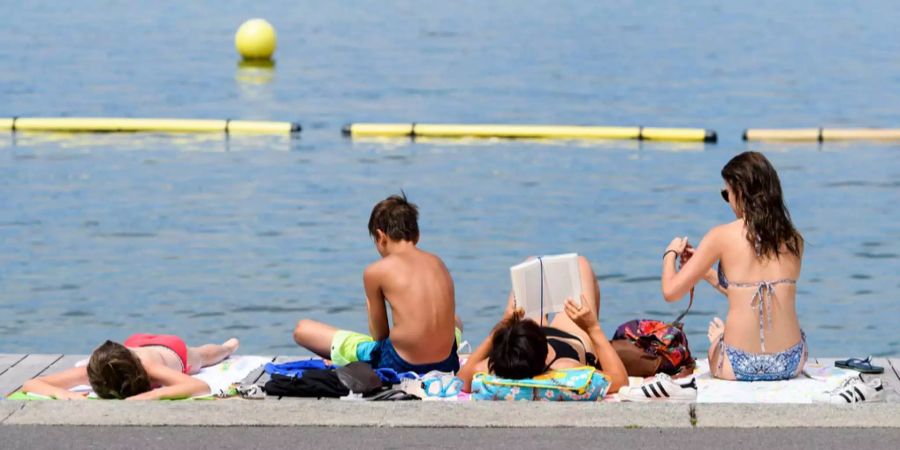 Badegäste geniessen das schöne Wetter am See.