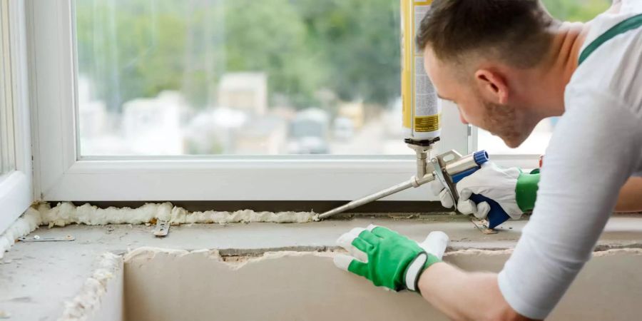 Nicht immer unbedenklich: Ein Arbeiter dichtet ein Fenster mit Polyurethan-Schaum ab. Bild: Shutterstock