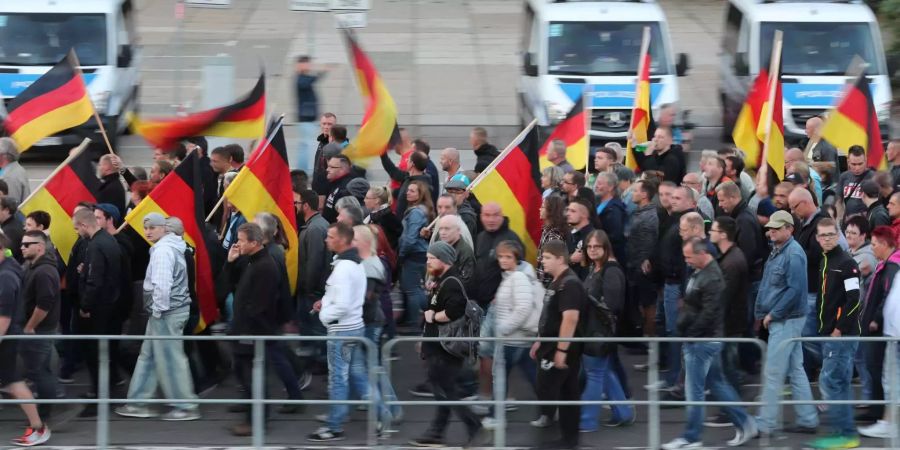 Teilnehmer einer Demonstration der rechtspopulistischen Bewegung Pro Chemnitz ziehen durch die Stadt.