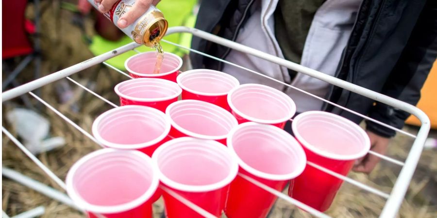 Eine Frau befüllt auf dem Zeltplatz des Hurricane Festivals Plastikbecher auf einem Wäschetrockner für das Spiel «Bierpong».